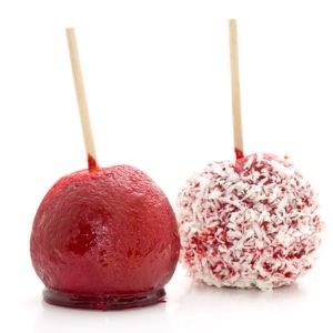 Two candy apples, one red and the other red covered in coconut flakes.