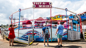 Riders enjoy Tilt-A-Whirl ride in motion at Jenkinson's Boardwalk. Visitors view and take photos of ride