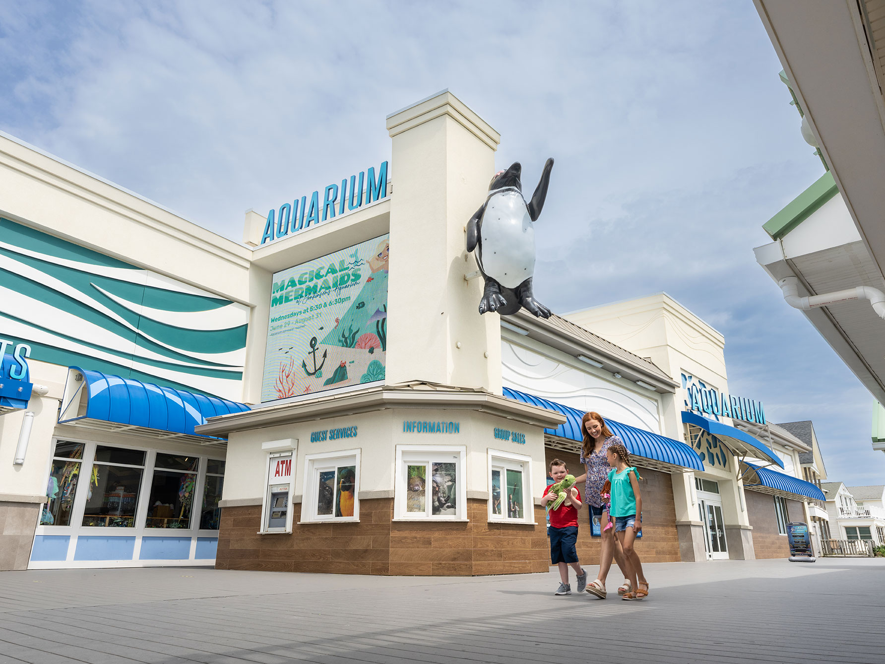 Family walking in front of Jenkinson's Aquarium with Turtle Plush from Jenkinson's Aquarium Gift Shop