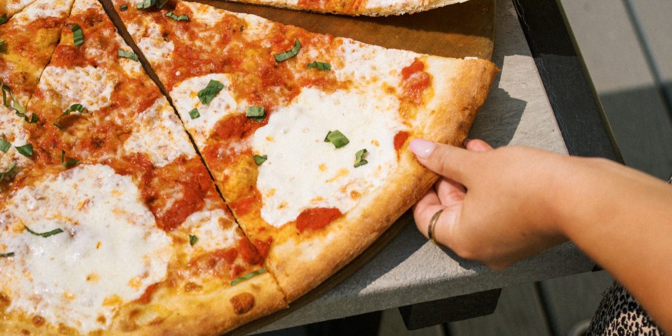 Customer taking a slice of Boardwalk pizza